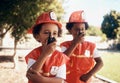 Two cute little african american boys having fun while playing outside in the backyard dressed as firemen and using Royalty Free Stock Photo