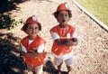 Two cute little african american boys having fun while playing outside in the backyard pretending to be firemen. Two Royalty Free Stock Photo