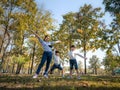 Two cute little Asian girls in summer outfits, having fun with a beautiful young mother smiling happily in the park. Motherhood Royalty Free Stock Photo