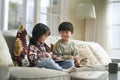 two cute little asian kids using digital tablet at home Royalty Free Stock Photo