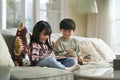 two cute little asian kids using digital tablet at home Royalty Free Stock Photo