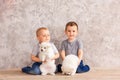 Two cute little baby boys playing with little white puppies Royalty Free Stock Photo