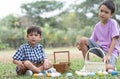 Two cute little Caucasian and Asian child boy hunting Easter eggs. kids collecting eggs in basket, counting eggs after play game Royalty Free Stock Photo