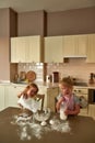 Two cute little children, boy and girl in aprons mixing ingredients while cooking, preparing dough together on the Royalty Free Stock Photo