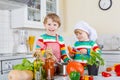 Two cute little children cooking italian soup and meal with fresh vegetables Royalty Free Stock Photo