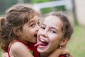 Two Happy little girls embracing and laughing at summer day