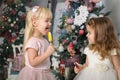 Two cute little girls in a festive New Year`s atmosphere with colored lollipops Royalty Free Stock Photo