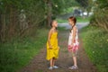 Two cute little girls friends in pine Park. Dialogue.