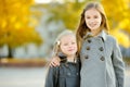 Two cute little girls having fun on beautiful autumn day. Happy children playing in autumn park. Kids gathering yellow fall foliag Royalty Free Stock Photo