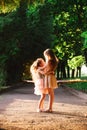 Two Cute little girls hugging and laughing at the garden at warm summer evening. Happy kids outdoors concept. Soft focused Royalty Free Stock Photo