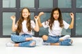 Two cute little girls meditate near the window.