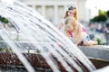 Two cute little girls playing by city fountain on hot and sunny summer day. Children having fun with water in summer. Royalty Free Stock Photo