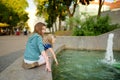 Two cute little girls playing by city fountain on hot and sunny summer day. Children having fun with water in summer Royalty Free Stock Photo