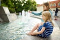 Two cute little girls playing by city fountain on hot and sunny summer day. Children having fun with water in summer Royalty Free Stock Photo