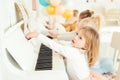 Two cute little girls playing piano in a studio. Royalty Free Stock Photo