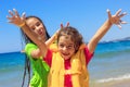 Two Cute Little Girls playing and smiling at the Sea Waves at sunset.  Summer Sunny Day, Ocean Coast, happy Kids concept Royalty Free Stock Photo