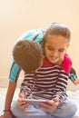 Two cute little Indian kids having fun by watching mobile device at home Royalty Free Stock Photo