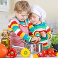 Two cute little kid boys cooking italian soup and meal with fresh vegetables Royalty Free Stock Photo