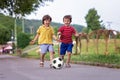 Two cute little kids, playing football together, summertime Royalty Free Stock Photo