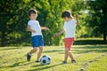 Two cute little kids, playing football together, summertime. Children playing soccer Royalty Free Stock Photo