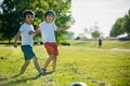 Two cute little kids, playing football together, summertime. Children playing soccer Royalty Free Stock Photo