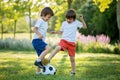 Two cute little kids, playing football together, summertime. Children playing soccer Royalty Free Stock Photo