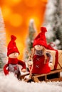 Two cute little red Christmas dolls with a sled