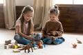 Happy children girls playing toys sit on floor at home Royalty Free Stock Photo