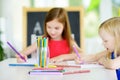 Two cute little sisters drawing with colorful pencils at a daycare Royalty Free Stock Photo