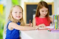 Two cute little sisters drawing with colorful pencils at a daycare Royalty Free Stock Photo