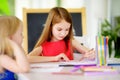 Two cute little sisters drawing with colorful pencils at a daycare. Creative kids painting together. Royalty Free Stock Photo