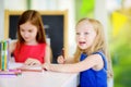 Two cute little sisters drawing with colorful pencils at a daycare. Creative kids painting together. Royalty Free Stock Photo
