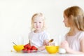 Two cute little sisters eating cereal in a kitchen Royalty Free Stock Photo