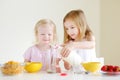 Two cute little sisters eating cereal in a kitchen Royalty Free Stock Photo