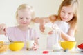 Two cute little sisters eating cereal in a kitchen Royalty Free Stock Photo