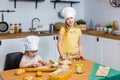 Two cute little sisters happily baking cookies and buns Royalty Free Stock Photo