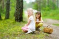 Two cute little sisters having fun during forest hike on beautiful summer day. Active family leisure with kids. Royalty Free Stock Photo