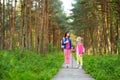 Two cute little sisters having fun during forest hike on beautiful summer day. Active family leisure with kids. Royalty Free Stock Photo