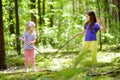 Two cute little sisters having fun during forest hike on beautiful summer day. Active family leisure with kids. Royalty Free Stock Photo