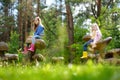 Two cute little sisters having fun on giant wooden mushrooms Royalty Free Stock Photo
