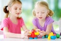 Two cute little sisters having fun together with modeling clay at a daycare. Creative kids molding at home. Children play with pla Royalty Free Stock Photo