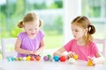 Two cute little sisters having fun together with modeling clay at a daycare. Creative kids molding at home. Children play with pla Royalty Free Stock Photo