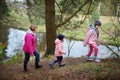 Two cute little sisters hiking in a forest with their grandmother on beautiful spring day. Children exploring nature Royalty Free Stock Photo