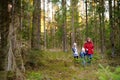 Two cute little sisters hiking in a forest with their grandmother on beautiful spring day. Children exploring nature Royalty Free Stock Photo