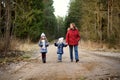 Two cute little sisters hiking in a forest with their grandmother on beautiful spring day. Children exploring nature Royalty Free Stock Photo