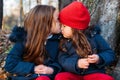 Two cute little sisters kissing. Children hugging and having fun in autumn park Royalty Free Stock Photo