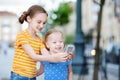 Two cute little sisters playing outdoor mobile game on their smart phones Royalty Free Stock Photo