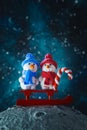 Two cute plasticine snowmen with a sled and a lollipop on the moon