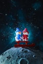 Two cute plasticine snowmen with sleds on the moon