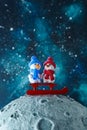 Two cute plasticine snowmen with sleds on the moon